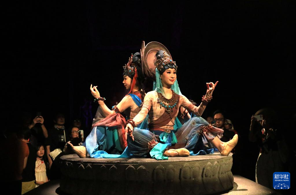 8月5日晚，游客在甘肅省敦煌市觀看大型洞窟式沉浸體驗劇《樂動敦煌》。 新華社發(fā)（張曉亮 攝）