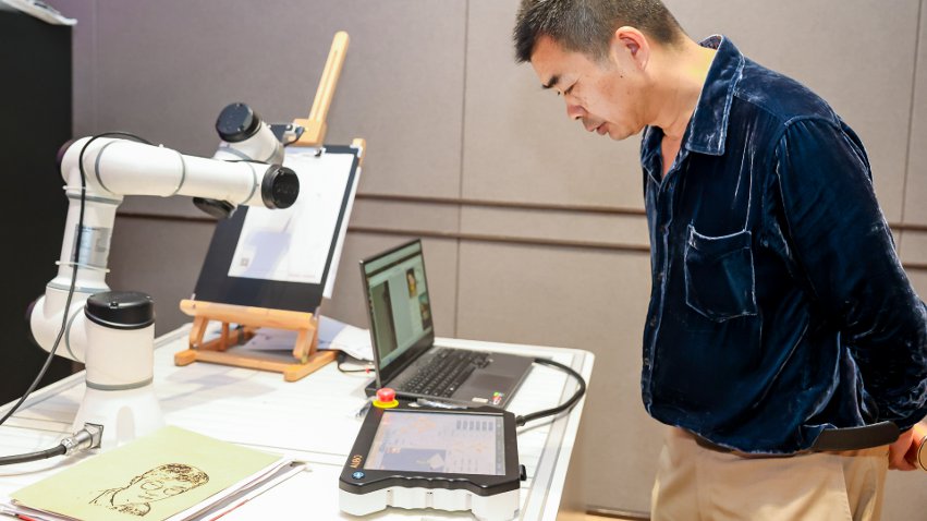 嘉賓體驗(yàn)遨博AI繪畫(huà)機(jī)器人。主辦方供圖